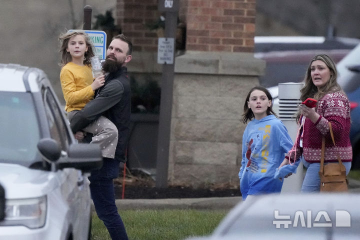 [AP/뉴시스] 여학생 총기난사 사건이 벌어진 후 학생들을 대피시킨 이웃 헬스센터에서 부모들이 아이들을 데리고 나오고 있다