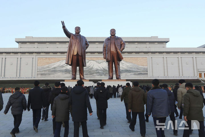 [평양=AP/뉴시스] 17일 북한 평양 시민들이 김정일 국방위원장 서거 13주기를 맞아 만수대언덕에 있는 김일성(왼쪽) 주석과 김정일 위원장 동상에 참배하고 있다. 김정일 위원장은 2011년 12월 17일 개인 전용 열차 안에서 사망했다. 2024.12.19.