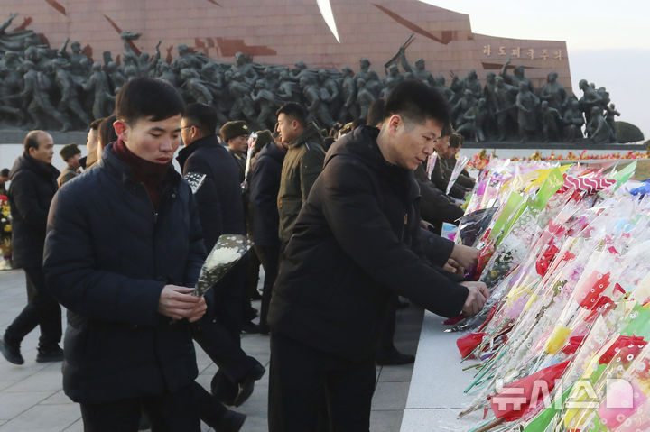 [평양=AP/뉴시스] 17일 북한 평양 시민들이 김정일 국방위원장 서거 13주기를 맞아 만수대언덕에 있는 김일성(왼쪽) 주석과 김정일 위원장 동상에 헌화하고 있다. 김정일 위원장은 2011년 12월 17일 개인 전용 열차 안에서 사망했다. 2024.12.18.