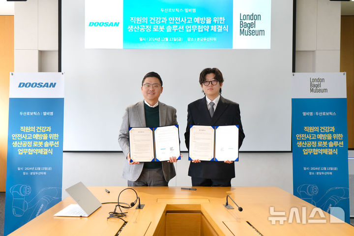 [서울=뉴시스]류정훈(왼쪽) 두산로보틱스 대표와 강관구 엘비엠 대표가 기념사진을 촬영하고 있다. (사진 = 두산로보틱스 제공)