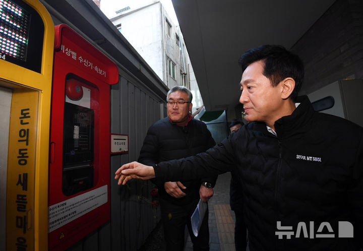 [서울=뉴시스] 김혜진 기자 = 오세훈 서울시장이 18일 오전 서울 종로구 돈의동 쪽방촌을 찾아 한파 대비 비상벨 수신기·속보기를 살펴보고 있다. (공동취재) 2024.12.18. photo@newsis.com