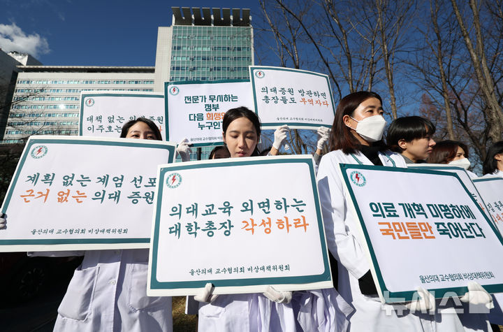 서울=뉴시스] 김진아 기자 = 울산의대 교수협의회 비상대책위원회 관계자들이 2024년 12월 18일 서울 송파구 서울아산병원 앞에서 윤석열 정부의 2천명 의대 증원에 반대하는 피켓 시위를 하고 있다. 2024.12.18. bluesoda@newsis.com