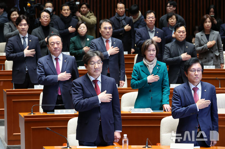 [서울=뉴시스] 조성우 기자 = 권성동(앞줄 왼쪽) 국민의힘 당 대표 권한대행 겸 원내대표가18일 오후 서울 여의도 국회에서 열린 의원총회에서 국기에 대한 경례를 하고 있다. 2024.12.18. xconfind@newsis.com