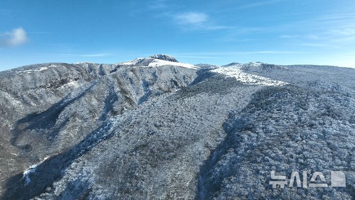 [제주=뉴시스] 임재영 기자 = 19일 오후 구름이 걷히면서 한라산의 겨울 위용이 드러났다. 전날 내린 많은 눈이 내리면서 한라산은 마치 하얀 융단을 펼쳐 놓은 것처럼 변했다. 해발 1400m이상에는 눈꽃과 서리꽃으로 뒤덮였고 낮은 곳의 벌거벗은 갈색 나무질감과 어울리면서 오묘한 대조를 이루고 있다. 2024.12.19. ijy788@newsis.com