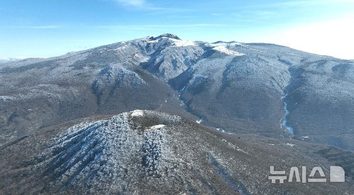 [제주=뉴시스] 임재영 기자 = 19일 오후 구름이 걷히면서 한라산의 겨울 위용이 드러났다. 전날 내린 많은 눈이 내리면서 한라산은 마치 하얀 융단을 펼쳐 놓은 것처럼 변했다. 해발 1400m이상에는 눈꽃과 서리꽃으로 뒤덮였고 낮은 곳의 벌거벗은 갈색 나무질감과 어울리면서 오묘한 대조를 이루고 있다. 2024.12.19. ijy788@newsis.com