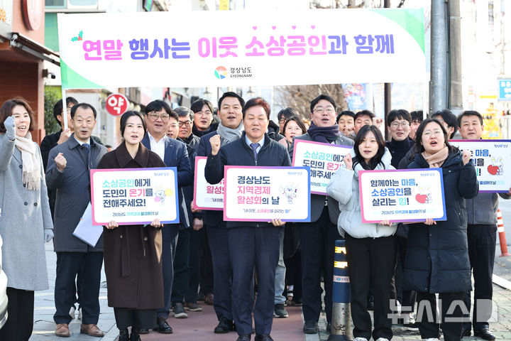 [창원=뉴시스]박완수(앞줄 가운데) 경남도지사가 19일 창원특례시 의창구 팔룡동 인근에서 기업인, 노동자, 도청 공무원 등과 함께 송년회, 가족 외식 등 연말연시 계획 정상 추진을 권하는 소비 진작 대도민 캠페인 동참을 호소하고 있다.(사진=경남도 제공) 2024.12.19. photo@newsis.com