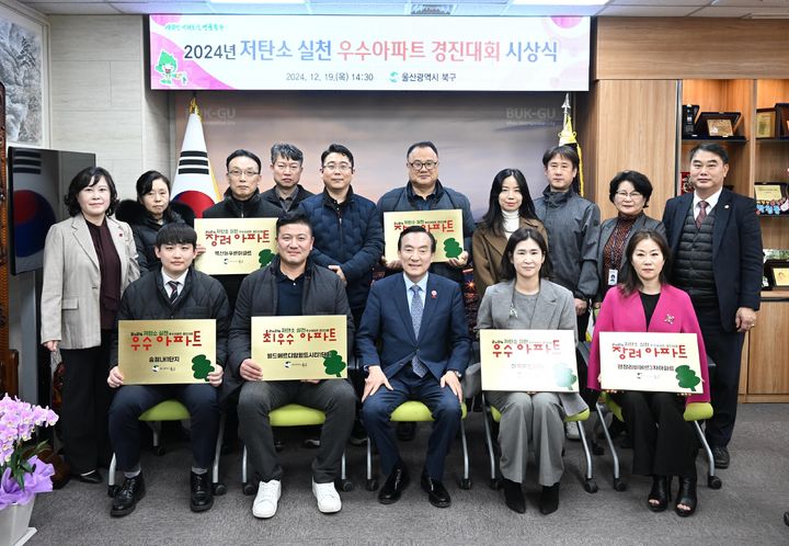 [울산=뉴시스] 19일 울산 북구청 구청장실에서 저탄소 실천 우수아파트 경진대회 시상식이 열린 가운데 박천동 북구청장이 우수아파트 대표들에게 현판을 전달한 뒤 기념촬영을 하고 있다. (사진=울산 북구 제공) 2024.12.19. photo@newsis.com *재판매 및 DB 금지