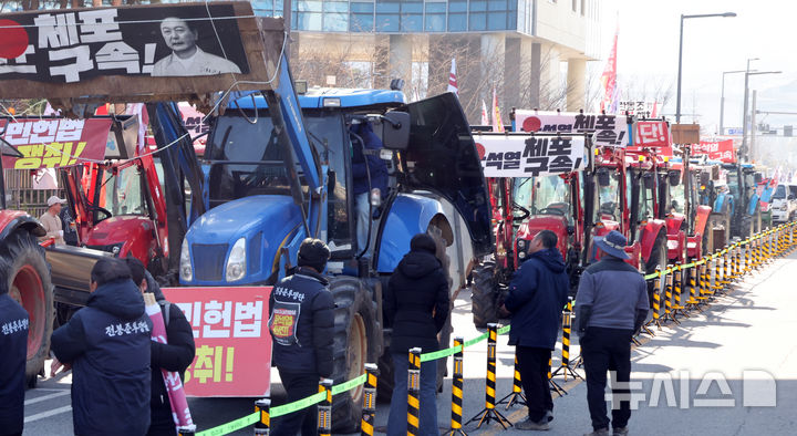 [세종=뉴시스] 강종민 기자 = 트랙터와 트럭 수십대를 몰고 상경행진에 나선 전국농민회총연맹 충남도연맹 농민들이 19일 세종시 정부세종청사 농림축산식품부 앞에서 결의대회를 열고 윤석열 대통령 체포와 구속, 개방 농정 철폐 등을 촉구하고 있다. 2024.12.19. ppkjm@newsis.com