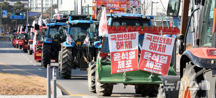 [세종=뉴시스] 강종민 기자 = 트랙터와 트럭 수십대를 몰고 상경행진에 나선 전국농민회총연맹 충남도연맹 농민들이 19일 세종시 정부세종청사 농림축산식품부 앞에서 윤석열 대통령 체포와 구속, 개방 농정 철폐 등을 촉구한 뒤 서울로 향하고 있다. 2024.12.19. ppkjm@newsis.com