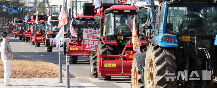 [세종=뉴시스] 강종민 기자 = 트랙터와 트럭 수십대를 몰고 상경행진에 나선 전국농민회총연맹 충남도연맹 농민들이 19일 세종시 정부세종청사 농림축산식품부 앞에서 윤석열 대통령 체포와 구속, 개방 농정 철폐 등을 촉구한 뒤 서울로 향하고 있다. 2024.12.19. ppkjm@newsis.com