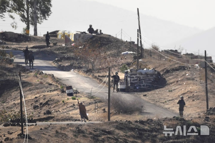 [마리예=AP/뉴시스]지난해 12월19일(현지시각) 시리아 남부 골란고원 인근 마리예 마을에서 흰색 깃발을 든 시리아 남성(왼쪽)이 이스라엘 군인들과 대화하기 위해 접근하고 있다. 2025.09.17.