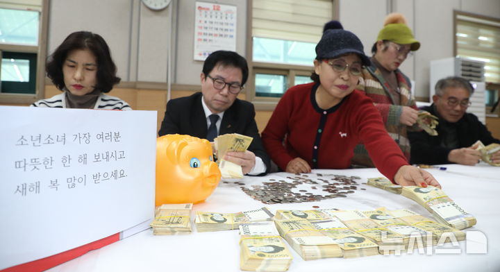 [전주=뉴시스] 김얼 기자 = 20일 전북 전주시 노송동 주민센터에서 직원들이 '얼굴 없는 천사'가 전달한 성금을 정리하고 있다. 얼굴없는천사는 성금과 함께 "소년소녀 가장 여러분 따뜻한 한 해 보내시고 새해 복 많이 받으세요."라고 적힌 편지를 함께 보내왔다. 2024.12.20. pmkeul@newsis.com