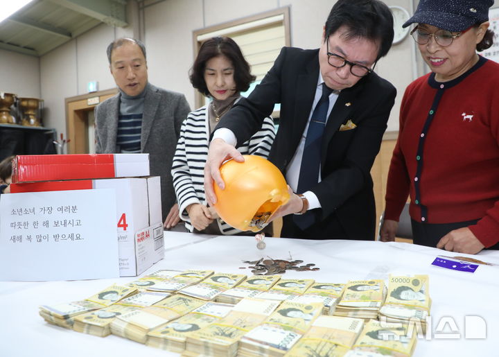 [전주=뉴시스] 김얼 기자 = 20일 전북 전주시 노송동 주민센터에서 직원들이 '얼굴 없는 천사'가 전달한 성금을 정리하고 있다. 얼굴없는천사는 성금과 함께 "소년소녀 가장 여러분 따뜻한 한 해 보내시고 새해 복 많이 받으세요."라고 적힌 편지를 함께 보내왔다. 2024.12.20. pmkeul@newsis.com