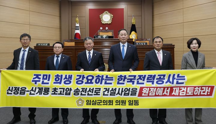 [임실=뉴시스] 20일 열린 임실군의회의 제342회 제2차 정례회 2차 본회의, 이성재 의원이 대표발의한 '신정읍~신계룡 초고압 송전선로 건설사업 전면 재검토 촉구 결의안'이 채택됐다. 결의안 발의자 이성재 의원(왼쪽 두번째)과 장종민 의장(왼쪽 네번째)을 비롯한 군의원들이 송전선로 사업의 재검토를 요구하며 사진을 찍고 있다. *재판매 및 DB 금지