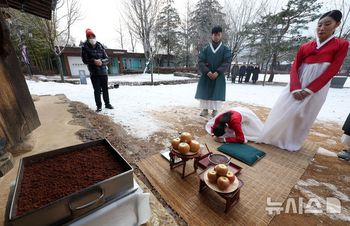 [서울=뉴시스] 홍효식 기자 = 절기상 동지인 21일 오전 서울 종로구 국립민속박물관에서 열린 '우리 작은 설, 동지(冬至)를 아세(亞歲)!' 행사에서 관계자들이 오촌댁 앞에서 전통 세시풍속을 계승하는 의미로 팥죽 고사를 지내고 있다. 2024.12.21. yesphoto@newsis.com