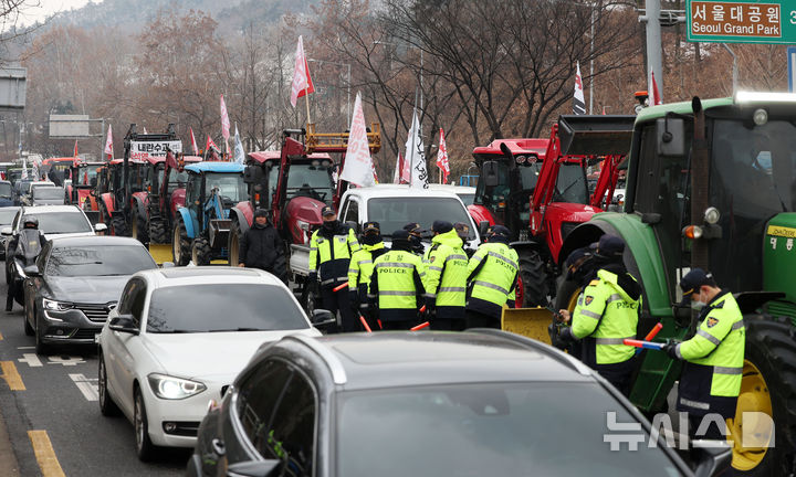 [서울=뉴시스] 홍효식 기자 = 전국농민회총연맹 전봉준 투쟁단 농민들이 21일 윤석열 대통령 체포 등을 촉구하며 트랙터와 트럭 수십 대를 몰고 상경하던 중 서울 남태령 고개 인근에서 경찰에 가로막혀 있다. 2024.12.21. yesphoto@newsis.com