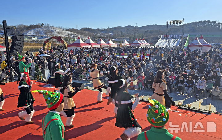 [임실=뉴시스] 김종효 기자 = '2024 임실산타축제' 이틀째인 22일 임실치즈테마파크, 산타복장 퍼레이드 공연팀의 무대를 많은 방문객들이 관람하고 있다. (사진=임실군청 제공) 2024.12.22. photo@newsis.com 