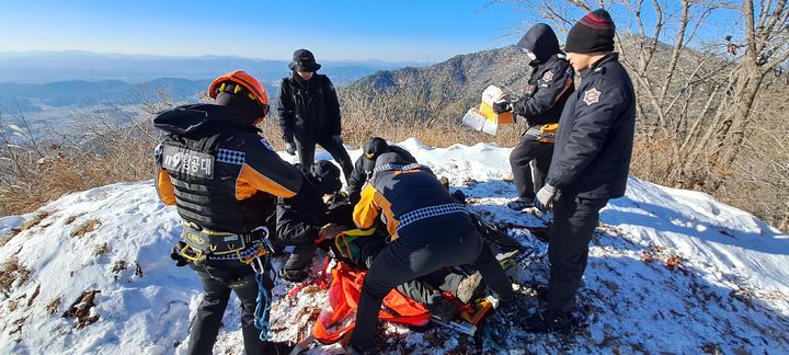 [남원=뉴시스] 22일 오전 11시46분께 전북 남원시 보절면의 만행산을 산행하던 등산객 A(50대)씨가 50m 높이에서 굴러 추락해 출동한 소방대원들이 응급처치를 하고 있다. (사진=전북특별자치도소방본부 제공) 2024.12.22. photo@newsis.com *재판매 및 DB 금지