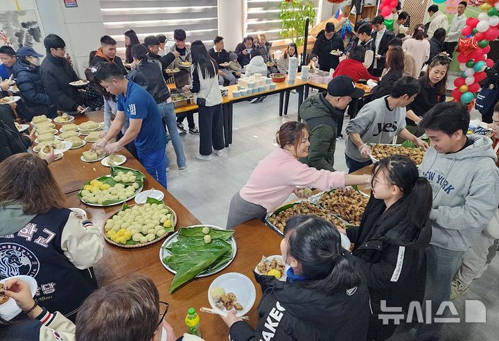 [창원=뉴시스]22일 경남이주민센터 2층 대회의실에서 열린 경남베트남교민회 주관 'STX와 함께하는 외국인주민 자국음식잔치' 참석자들이 준비된 음식을 나눠 먹고 있다.(사진=경남이주민센터 제공) 2024.12.22. photo@newsis.com.