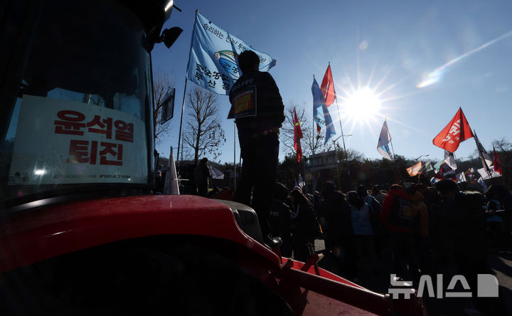 [서울=뉴시스] 추상철 기자 = 전국농민회총연맹 전봉준 투쟁단의 '윤석열 대통령 체포 등을 촉구'하는 트랙터 대행진이 1박2일째 이어진 22일 오전 서울 서초구 남태령역 인근에서 집회 참가자가 시위를 하고 있다. 2024.12.22. scchoo@newsis.com