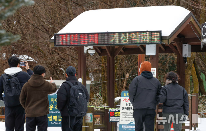 [제주=뉴시스] 우장호 기자 = 제주시 어리목 탐방로 입구를 찾은 관광객들이 아쉬운 발길을 돌리고 있다. 2024.12.22. woo1223@newsis.com