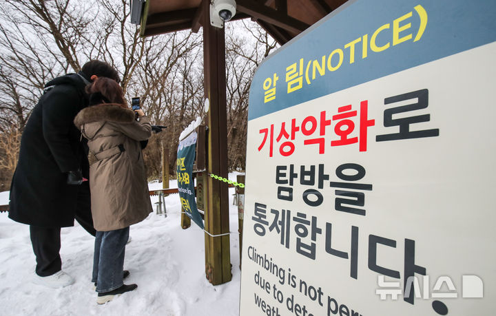 [제주=뉴시스] 우장호 기자 = 한라산 정상부 출입이 전면 통제된 지난해 12월22일 오전 제주시 어리목 탐방로 입구를 찾은 관광객들이 아쉬운 발길을 돌리고 있다. 2024.12.22. woo1223@newsis.com