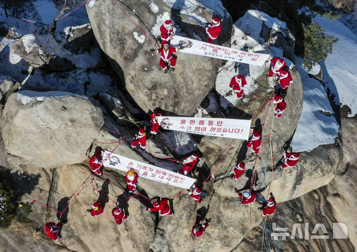 [남양주=뉴시스] 김근수 기자 = 22일 오후 경기도 남양주시 불암산 정상에서 국립공원 산악안전지원단 소속회원들이 산타복을 입고 안전산행을 기원하는 새해 맞이 퍼포먼스를 하고 있다. 2024.12.22. ks@newsis.com