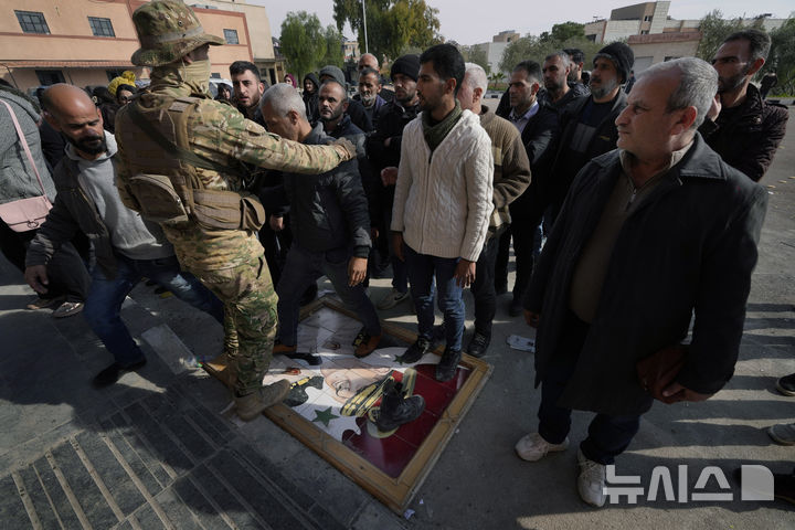 [다마스쿠스=AP/뉴시스] 시리아에서 옛 독재자 바샤르 알아사드 전 대통령을 따르는 무장 세력과 시리아 과도정부 병력 간 충돌로 16명이 사망했다고 6일(현지 시간) AFP통신이 보도했다. 사진은 지난해 12월 23일 시리아 다마스쿠스에서 시민들이 아사드의 초상화를 짓밟는 모습. 2025.03.07. 