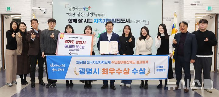 [광명=뉴시스]박승원 광명시장(사진 왼쪽에서 일곱 번째)이 '2024년 전국지방자치단체 주민참여예산제도 성과평가' 최우수상 수상을 기념해 예산법무과 직원들과 기념사진을 촬영하고 있다.(사진=광명시 제공)2024.12.23.photo@newsis.com
