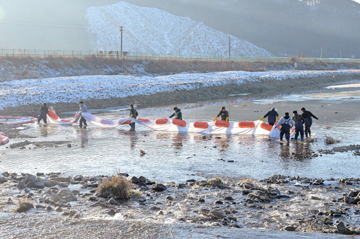 [공주=뉴시스] 21일 충남 공주시 유구읍 일대 서산영덕고속도로에서 탱크로리 차량이 미끄러지면서, 유츨된 벙커A유가 인근 유구천에 유입되자, 공주시 등 방제 당국이 부직포로 방제작업을 벌이고 있다.(사진=공주시 제공) 2024.12.23. photo@newsis.com *재판매 및 DB 금지