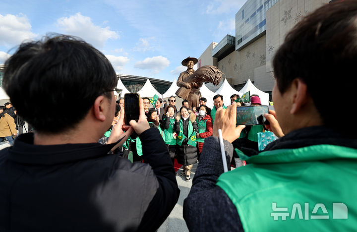 [대구=뉴시스] 이무열 기자 = 23일 대구 동대구역 광장에서 열린 박정희 동상 제막식에서 시민들이 동상을 배경으로 기념촬영을 하고 있다. 2024.12.23. lmy@newsis.com