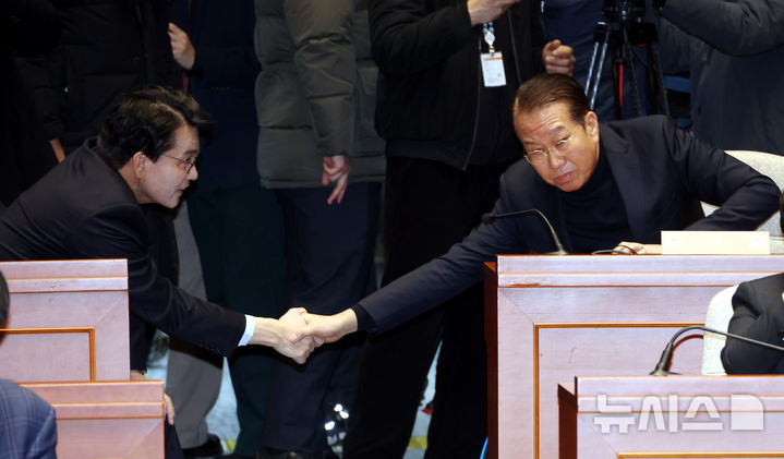 [서울=뉴시스] 조성봉 기자 = 국민의힘 비대위원장에지명된 권영세 의원이 24일 오전 서울 여의도 국회에서 열린 의원총회에서 윤상현(왼쪽) 의원과 악수를 하고 있다. 2024.12.24. suncho21@newsis.com