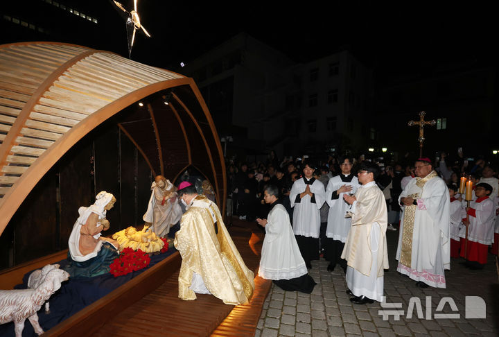 [서울=뉴시스] 김선웅 기자 = 천주교 서울대교구장 정순택 대주교가 성탄절인 25일 서울 중구 명동 천주교 서울대교구 명동대성당에서 주님 성탄 대축일 밤 미사를 앞두고 아기 예수를 말 구유에 안치하는 '구유 예절' 의식을 행하고 있다. (공동취재) 2024.12.25. photo@newsis.com