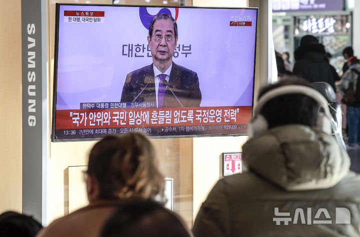 [서울=뉴시스] 정병혁 기자 = 지난 26일 서울 용산구 서울역 대합실에서 시민들이 한덕수 대통령 권한대행 국무총리의 대국민담화를 바라보고 있다. 2024.12.26. jhope@newsis.com