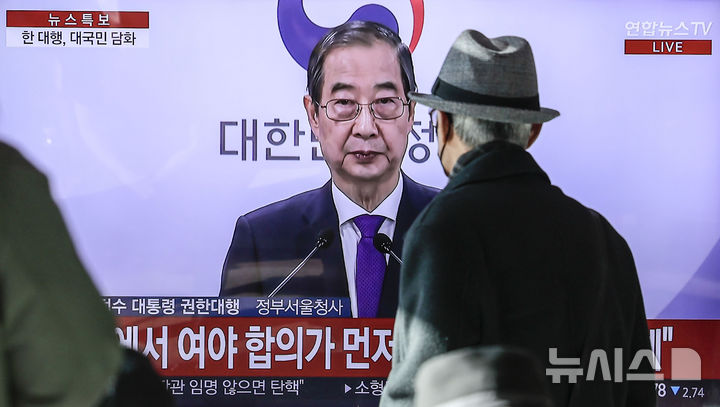 [서울=뉴시스] 정병혁 기자 = 26일 서울 용산구 서울역 대합실에서 시민들이 한덕수 대통령 권한대행 국무총리의 대국민담화를 바라보고 있다. 2024.12.26. jhope@newsis.com