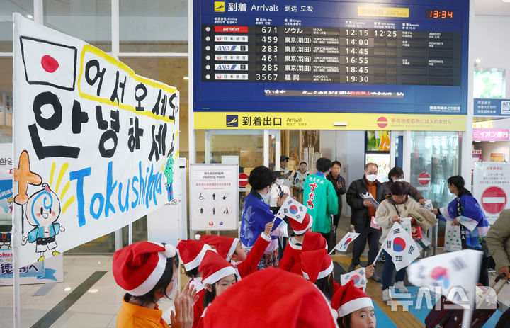 [도쿠시마(일본)=뉴시스] 전신 기자 = 26일 일본 도쿠시마공항에서 열린 '이스타항공 도쿠시마 첫 취항' 기념 행사에서 한국 탑승객들이 도쿠시마 유치원생들의 환영을 받으며 입국장을 나서고 있다. 이스타항공이 국내 최초로 단독 취항하는 인천-도쿠시마 노선은 주 3회(화, 목, 토) 운항한다. 2024.12.26. photo1006@newsis.com