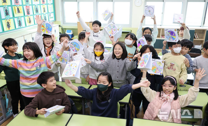 [서울=뉴시스] 황준선 기자 = 27일 오후 서울 구로구 서울개봉초등학교에서 열린 방학식에서 학생들이 방학 생활계획표를 들어보이고 있다. 2024.12.27. hwang@newsis.com