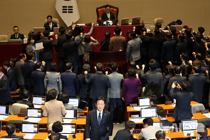 [서울=뉴시스] 권창회 기자 = 이재명 더불어민주당 대표가 27일 오후 서울 여의도 국회에서 열린 제420회국회(임시회) 제2차 본회의에서 국무총리(한덕수) 탄핵소추안 투표를 마친뒤 항의하는 국민의힘 의원들 뒤로 미소 지으며 이동하고 있다. 2024.12.27. kch0523@newsis.com