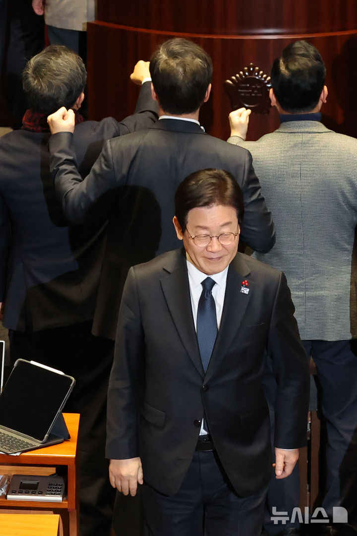 [서울=뉴시스] 권창회 기자 = 이재명 더불어민주당 대표가 27일 오후 서울 여의도 국회에서 열린 제420회국회(임시회) 제2차 본회의에서 국무총리(한덕수) 탄핵소추안 투표를 마친뒤 항의하는 국민의힘 의원들 뒤로 미소 지으며 이동하고 있다. 2024.12.27. kch0523@newsis.com