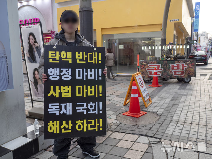 [전주=뉴시스] 강경호 기자 = 28일 전북 전주시 전주객사 거리에서 윤석열 대통령의 탄핵을 반대하는 한 시민이 피켓을 든 채 1인 시위에 나서고 있다. 2024.12.28. lukekang@newsis.com