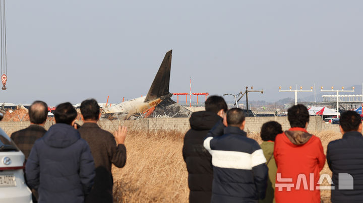 [무안=뉴시스] 이영환 기자 = 전남 무안국제공항에서 여객기 착륙 도중 충돌 사고가 난 29일 오후 무안국제공항에서 시민들이 사고현장을 살펴보고 있다. 2024.12.29. 20hwan@newsis.com