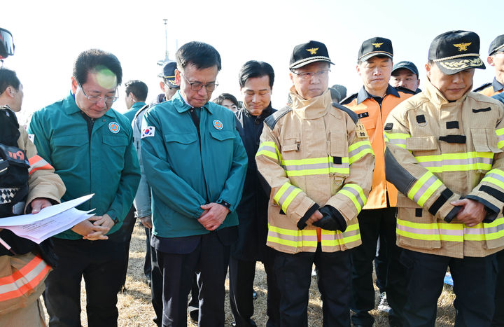 [서울=뉴시스] 최진석 기자 = 최상목 대통령 권한대행 부총리 겸 기획재정부 장관이 29일 전남 무안국제공항 제주항공 항공기 사고 현장을 찾아 묵념하고 있다. (사진=기획재정부 제공) 2024.12.29. photo@newsis.com *재판매 및 DB 금지