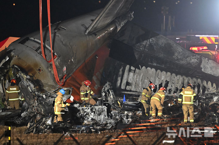 [무안=뉴시스] 이영주 기자 = 제주항공 소속 여객기 착륙 도중 충돌 사고가 발생한 29일 오후 전남 무안국제공항 사고현장에서 소방 당국이 야간 수습 작업을 벌이고 있다. 2024.12.29. leeyj2578@newsis.com