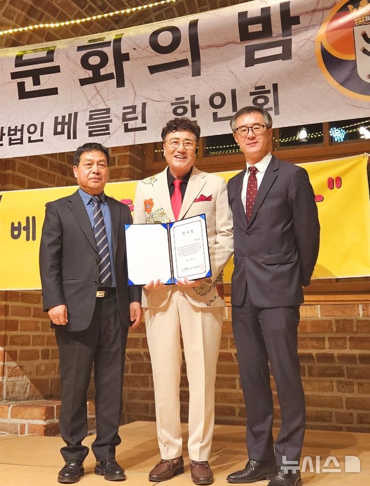 [창원=뉴시스]경남 밀양 출신 박태희(가운데) 트로트 가수가 지난 21일(현지시각) 오후 열린 독일 베를린한인회 2024년 송년의 밤 행사에 참석해 초청공연을 마친 후 받은 감사장을 들고 한인회 관계자들과 기념촬영하고 있다.(사진=박태희 제공) 2024.12.30. photo@newsis.com