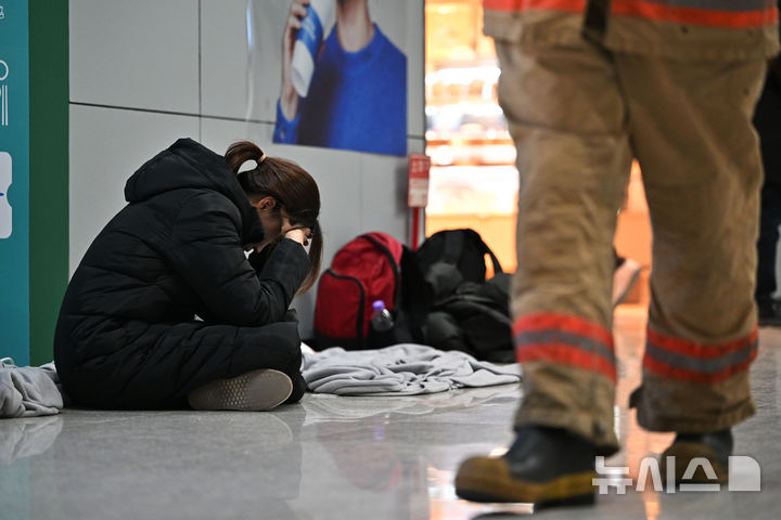 [무안=뉴시스] 이영주 기자 = 제주항공 소속 여객기 착륙 도중 충돌 사고 이튿날인 30일 오전 전남 무안군 무안국제공항 2층 대합실에서 한 유족이 주저앉아 머리를 붙잡고 있다. 2024.12.30. leeyj2578@newsis.com