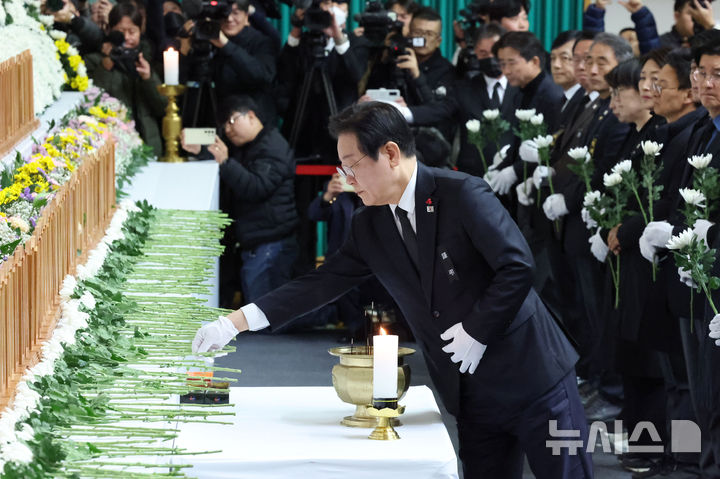 [무안=뉴시스] 이영주 기자 = 이재명 더불어민주당 대표가 30일 전남 무안 스포츠파크에 차려진 제주항공 여객기 참사 합동 분향소에서 헌화를 하고 있다. (공동취재) 2024.12.30. photo@newiss.com