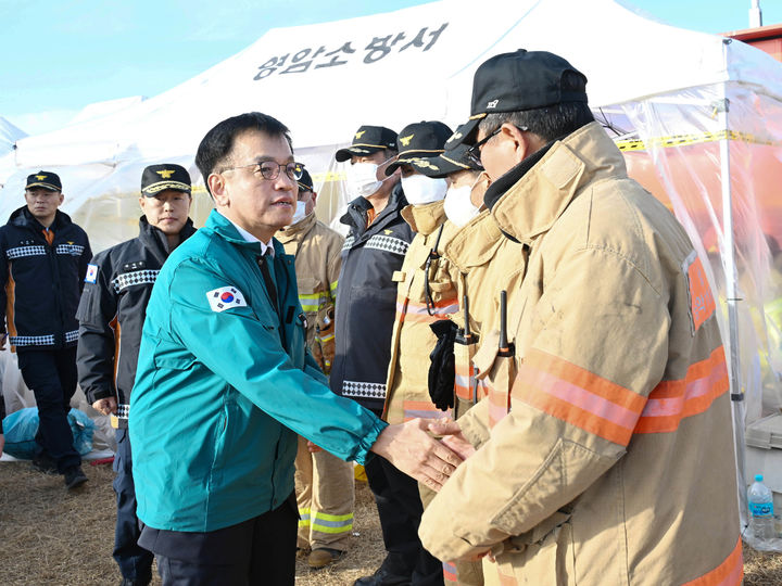 [무안=뉴시스] 조수정 기자 = 최상목 대통령 권한대행 부총리 겸 기획재정부 장관이 30일 오후 전남 무안국제공항 제주항공 여객기 참사 현장을 방문해 현장 구조대원을 격려하며 노고에 감사를 전하고 있다. (사진=기획재정부 제공) 2024.12.30. photo@newsis.com *재판매 및 DB 금지