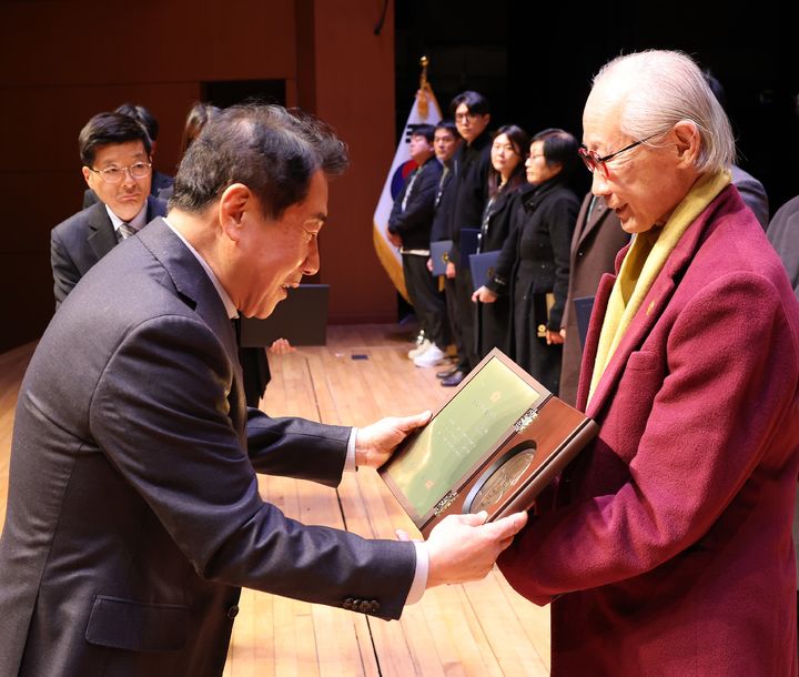 [양산=뉴시스] 나동연 시장이 안창수 화백에게 제1회 양산시 예술인상 상패를 수여하고 있다. (사진=양산시 제공) 2024.12.31. photo@newsis.com *재판매 및 DB 금지