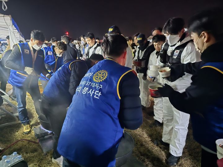 [무안=뉴시스] 제주항공 여객기 참사 당일인 29일 전남 무안국제공항 사고 현장 주변에서 국제로타리 3710지구 봉사단이 구조·수습 작업을 벌이는 소방·경찰 관계자들에게 떡국을 나누고 있다. (사진 = 국제로타리 3710지구 제공) photo@newsis.com *재판매 및 DB 금지