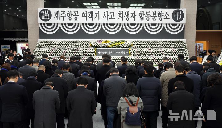 [부산=뉴시스] 하경민 기자 = 부산 연제구 부산시청 1층 로비에 마련된 제주항공 여객기 사고 희생자 합동분향소에서 31일 더불어민주당 부산시당 관계자와 시민 등이 헌화 및 분향을 한 뒤 묵념을 하고 있다.  부산시는 국가애도기간에 맞춰 내년 1월4일까지 매일 오전 8시~오후 10시 시민들이 분향할 수 있도록 지원할 계획이다. 2024.12.31. yulnetphoto@newsis.com